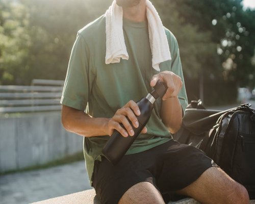 Person drinking water from a reusable bottle during a break