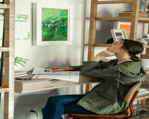 Woman doing a light stretch at her home office desk